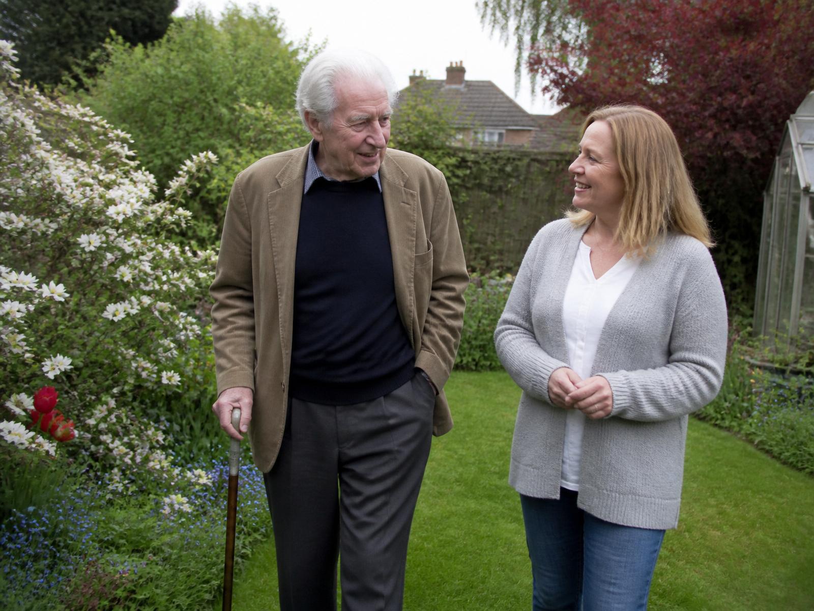 Older man walking with a companion in the park